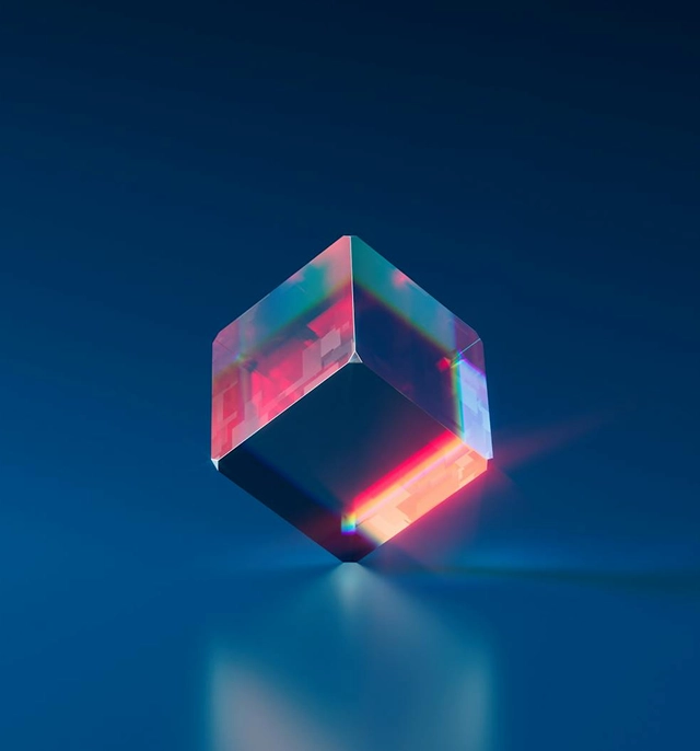 A glass prism splitting light into spectral colors.